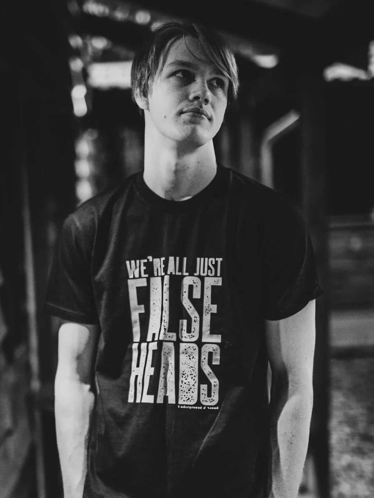 Black and white picture of Charlie Gregory, the drummer for the band False Heads, wearing a band tee