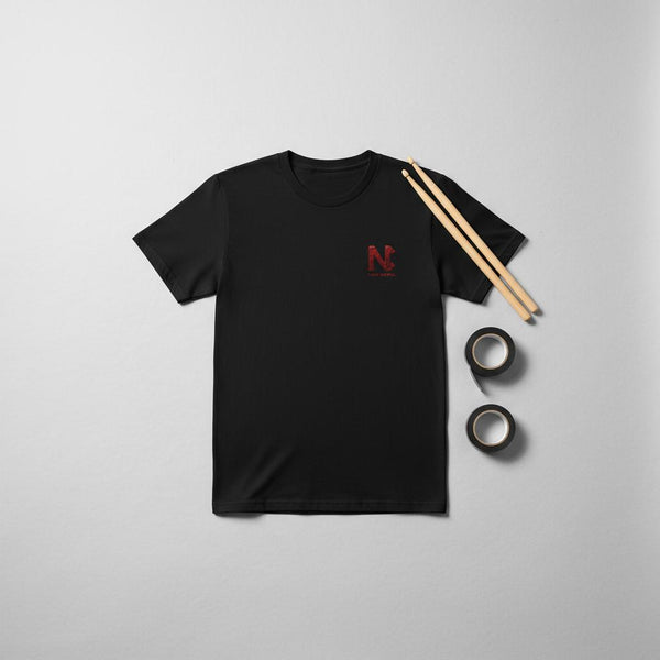 flat lay image of a Nic Collins x Above Average DRMMR tee with drumsticks and tape in the picture