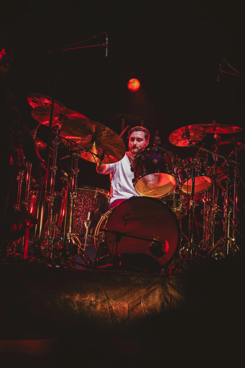Nic Collins drumming on stage in red lighting