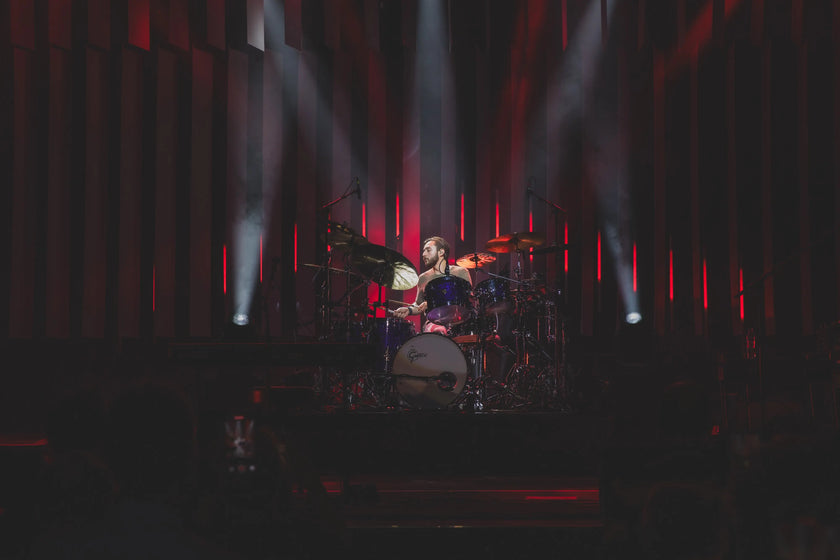 Nic Collins on stage playing drums