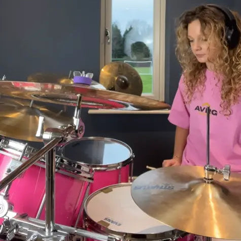 drummer lola teague behind the kit wearing her pink Above Average Clothing tee