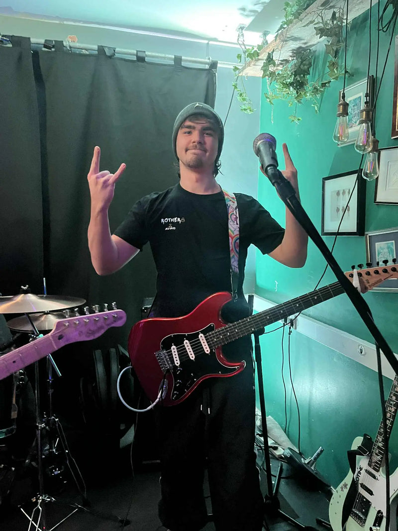 serotine guitarist jake rothera on stage before a gig, wearing his above average custom tee