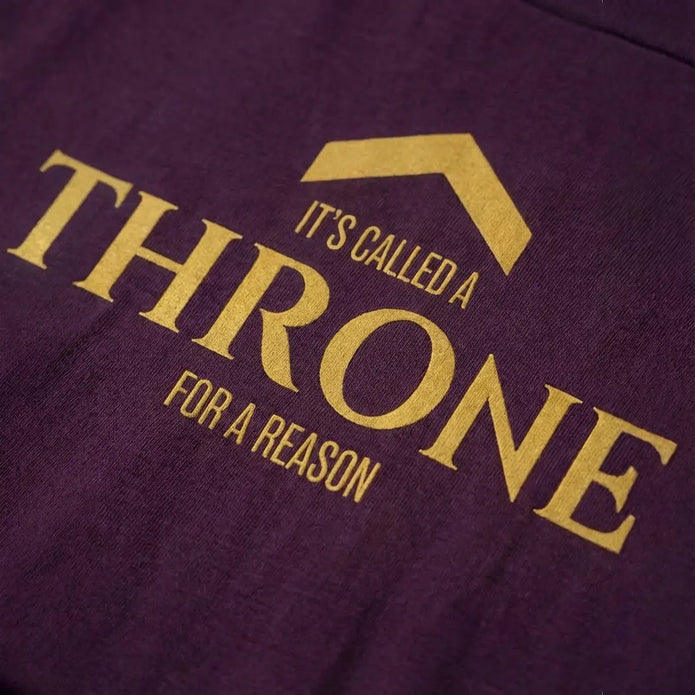 Close-up of “It’s called a throne for a reason” logo on DRMMR t-shirt by Above Average Clothing, mindset-led sustainable streetwear for drummers inspired by confidence, discipline, and identity.