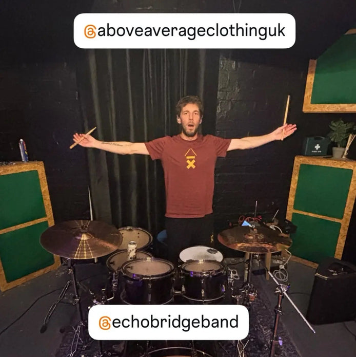 EchoBridge drummer Lloyd Crabb at his drum kit, wearing an Above Average DRMMR tee