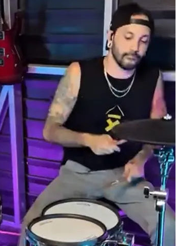 J Boye playing drumes wearing his ABove Average drummer ascent sleeveless tee