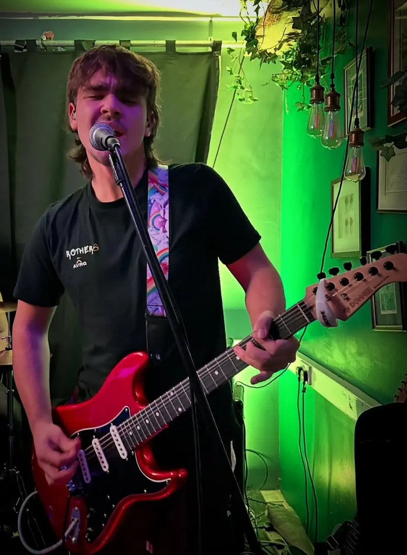 serotine guitarist ake rothera on stage wearing his customised above average design tee