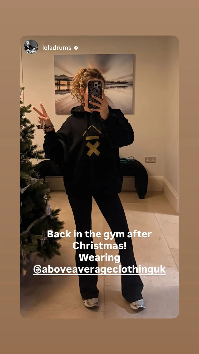 drummer lola teague taking a selfie in her Above Average Clothing hoodie