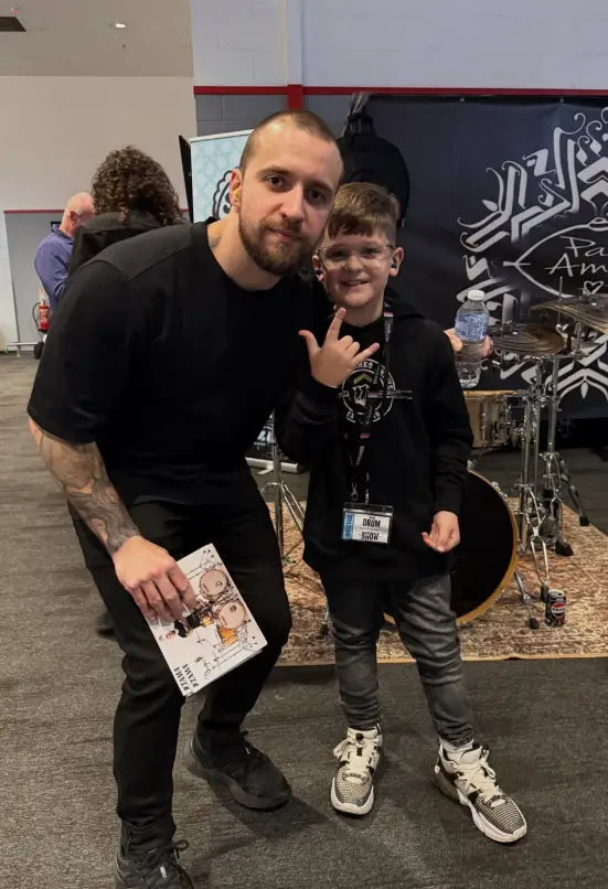 Sully Janko having his picture taken with Eloy Casagrande. Sully is wearing his own design Above Average hoodie