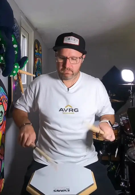 Tom Howarth playing a practice pad wearing his Above Average DRMMR tee