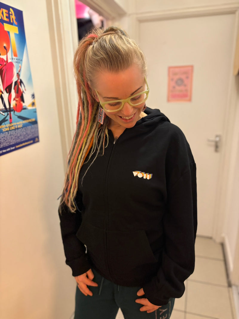drummer vicky o neon wearing ne of her own Above Average Clothing pieces. A black zip up hoodie with her rainbow VON logo